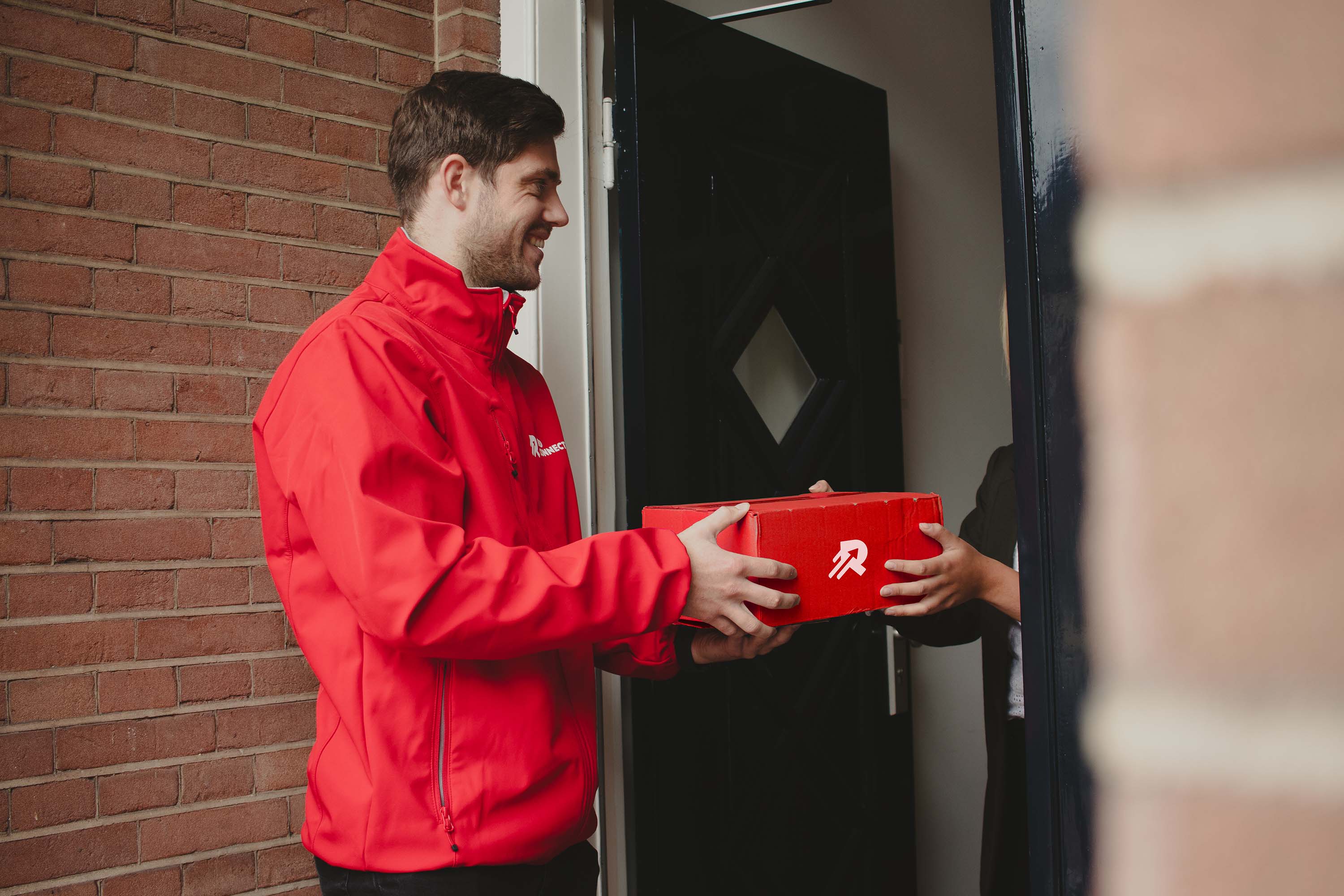 Red Connect medewerker overhandigt het installatiepakket